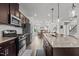 Beautiful kitchen featuring dark cabinets, stainless steel appliances, and a granite island flowing into the dining area at 5818 Humanity Ln, Raleigh, NC 27616