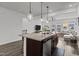 Modern kitchen island with granite countertops and stainless steel dishwasher with views to the living room at 5818 Humanity Ln, Raleigh, NC 27616
