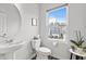 Bright powder room featuring a pedestal sink, toilet, and a window that overlooks the neighborhood at 5818 Humanity Ln, Raleigh, NC 27616