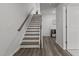 A well-lit staircase features wood-style flooring and modern white walls for a clean and stylish look at 5818 Humanity Ln, Raleigh, NC 27616