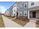 Street view of well-maintained townhomes with manicured lawns and inviting entrances under a clear blue sky at 5818 Humanity Ln, Raleigh, NC 27616