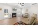 Cozy living room featuring a fireplace, ceiling fan, and an open layout with wood-look floors and a neutral color palette at 61 Okra Ct, Selma, NC 27576