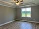 Bright, spacious bedroom with a ceiling fan, tray ceiling, and hardwood floors, and a large window overlooking nature at 70 Prency Ln, Middlesex, NC 27557