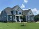 Charming two-story home featuring a manicured lawn, blue siding, and a welcoming front porch at 70 Prency Ln, Middlesex, NC 27557