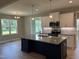 Bright kitchen featuring an island with granite countertops, stainless steel appliances, and views to the yard at 70 Prency Ln, Middlesex, NC 27557