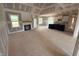 Open-concept living room featuring a fireplace, large windows, and seamless transition to the kitchen area at 70 Prency Ln, Middlesex, NC 27557
