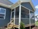 A screened-in porch features natural light, outdoor living space, wood flooring, and a ceiling fan for optimal comfort at 70 Prency Ln, Middlesex, NC 27557
