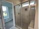 Bathroom featuring tile shower with glass door, herringbone floor tile, and a view into the walk-in closet at 70 Prency Ln, Middlesex, NC 27557