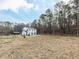 Expansive backyard with a white two-story home, fenced perimeter, and wooded backdrop at 7408 Stable End Rd, Raleigh, NC 27613