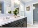 Bathroom with a double sink vanity, decorative plant, framed art, and a view of the commode at 7408 Stable End Rd, Raleigh, NC 27613