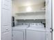 Compact laundry room with white washer and dryer, and white shelving, for efficient space at 7408 Stable End Rd, Raleigh, NC 27613