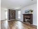 Bright living room featuring a fireplace, hardwood floors, and built-in shelving at 7408 Stable End Rd, Raleigh, NC 27613