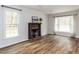 Spacious living room with hardwood floors, fireplace, and large windows offering natural light at 7408 Stable End Rd, Raleigh, NC 27613