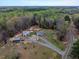 Aerial view displays property with large outbuildings, lush trees, and circular driveway at 765 Townsville Landing Rd, Henderson, NC 27537