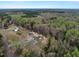 Aerial view showcases the property surrounded by lush greenery and mature trees at 765 Townsville Landing Rd, Henderson, NC 27537
