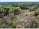 Aerial view of home with long driveway, metal outbuildings, and wooded surroundings at 765 Townsville Landing Rd, Henderson, NC 27537