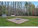 Backyard with a gravel firepit feature surrounded by grass and trees at 765 Townsville Landing Rd, Henderson, NC 27537
