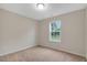 Bedroom features neutral carpet and a window with outdoor views at 765 Townsville Landing Rd, Henderson, NC 27537
