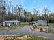 Exterior view of home with a large outbuilding, circular driveway, and a landscaped water feature at 765 Townsville Landing Rd, Henderson, NC 27537