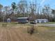 Property has metal outbuildings and a trailer, surrounded by lush trees at 765 Townsville Landing Rd, Henderson, NC 27537