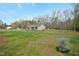 Large front yard with a view of the house, surrounded by trees and lawn at 765 Townsville Landing Rd, Henderson, NC 27537