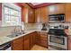 Well-lit kitchen with wooden cabinets, granite countertops, and stainless-steel appliances at 801 Myrtle Grove Ln, Apex, NC 27502