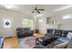 Bright living room featuring hardwood floors, a fireplace, and comfortable leather seating at 801 Myrtle Grove Ln, Apex, NC 27502