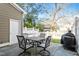Outdoor patio area with table, chairs, white fence, and grill for relaxing and entertaining at 801 Myrtle Grove Ln, Apex, NC 27502