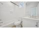 Well-lit bathroom showcases bathtub and shower combo, bright white tile, and a vanity with granite counters at 802 Pleasant Dr, Durham, NC 27703