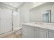 Modern bathroom featuring tiled floors, gray cabinets, glass shower, and bright lighting at 802 Pleasant Dr, Durham, NC 27703