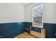 Bedroom features wood look floors, blue wainscoting, and a large window at 802 Pleasant Dr, Durham, NC 27703