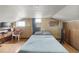 Large bedroom features laminate flooring, wood paneled walls, and natural light from several windows at 902 Bragg St, Sanford, NC 27330