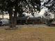 Cozy brick home features a covered porch, a gravel driveway and a mature shade tree in the front yard at 902 Bragg St, Sanford, NC 27330