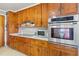 Well-lit kitchen with wooden cabinets, stainless steel oven, microwave and flat cooktop, and bright white countertops at 902 Bragg St, Sanford, NC 27330