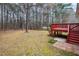 Spacious backyard with mature trees and a red painted deck at 936 Amersham Ln, Wake Forest, NC 27587