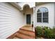 Close up of front door featuring brick steps, arched window, and well-kept landscaping at 936 Amersham Ln, Wake Forest, NC 27587