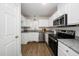 Well-lit kitchen with white cabinetry, stainless steel appliances, and granite countertops at 936 Amersham Ln, Wake Forest, NC 27587