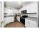 Well-lit kitchen with white cabinetry, stainless steel appliances, and granite countertops at 936 Amersham Ln, Wake Forest, NC 27587