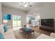 Bright open-concept living room featuring modern furniture, wood floors and sliding glass doors to the backyard at 101 Shelfit Trl, Oxford, NC 27565