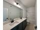 Modern bathroom featuring double vanity, quartz countertop, and black fixtures, complemented by a bathtub with shower at 108 N Stonemill Trl # Homesite 254, Wilson's Mills, NC 27520