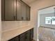 Butlers pantry features gray cabinets, white backsplash, and light countertops at 108 N Stonemill Trl # Homesite 254, Wilson's Mills, NC 27520