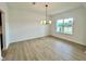 Airy dining room with wood-look flooring, a modern chandelier, and a large window at 108 N Stonemill Trl # Homesite 254, Wilson's Mills, NC 27520