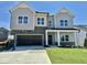 Two-story home featuring gray siding, stone accents, and a spacious two-car garage at 108 N Stonemill Trl # Homesite 254, Wilson's Mills, NC 27520