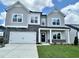 Charming two-story home with gray siding, stone accents, manicured lawn and attached two car garage at 108 N Stonemill Trl # Homesite 254, Wilson's Mills, NC 27520
