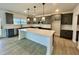 Modern kitchen with gray cabinets, large island, and stainless steel appliances, perfect for cooking and entertaining at 108 N Stonemill Trl # Homesite 254, Wilson's Mills, NC 27520