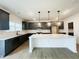 Modern kitchen featuring gray cabinetry, an island with quartz countertops and pendant lighting at 108 N Stonemill Trl # Homesite 254, Wilson's Mills, NC 27520