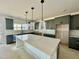 Modern kitchen featuring gray cabinets, an island with light countertops, and modern lighting at 108 N Stonemill Trl # Homesite 254, Wilson's Mills, NC 27520