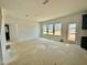 Open living space with three bright windows and a door to the backyard at 108 N Stonemill Trl # Homesite 254, Wilson's Mills, NC 27520