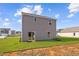 Back exterior view with a sliding glass door and a spacious, green lawn at 110 Rhino Bnd, Oxford, NC 27565