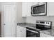 Close-up of a modern kitchen with granite countertops, a stainless steel oven and microwave, and ample storage space at 110 Rhino Bnd, Oxford, NC 27565